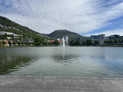 A decorative fountain in Bergen city centre surrounded by mountains with houses littered throughout