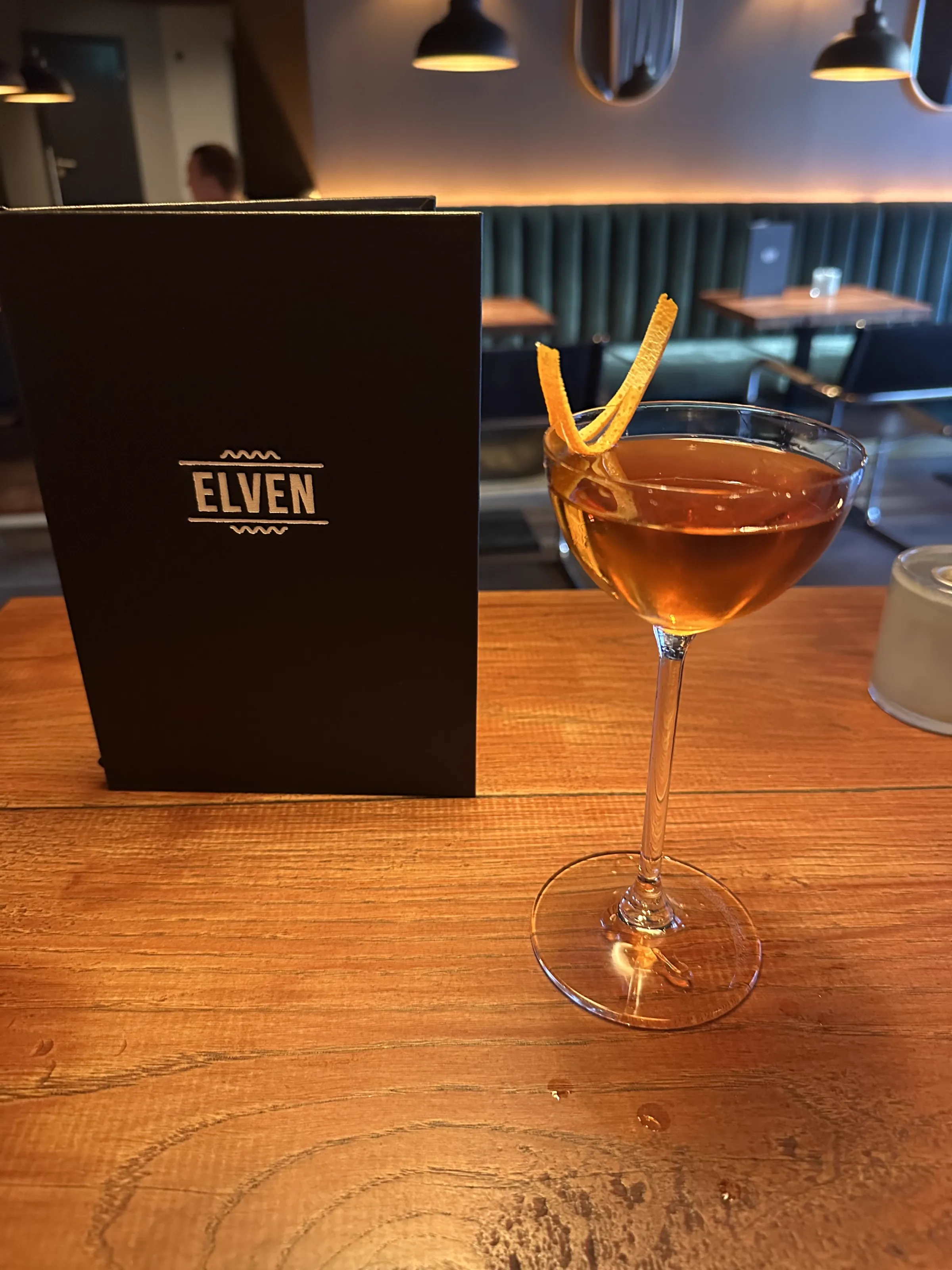 A whiskey cocktail with garnish at Elven bar