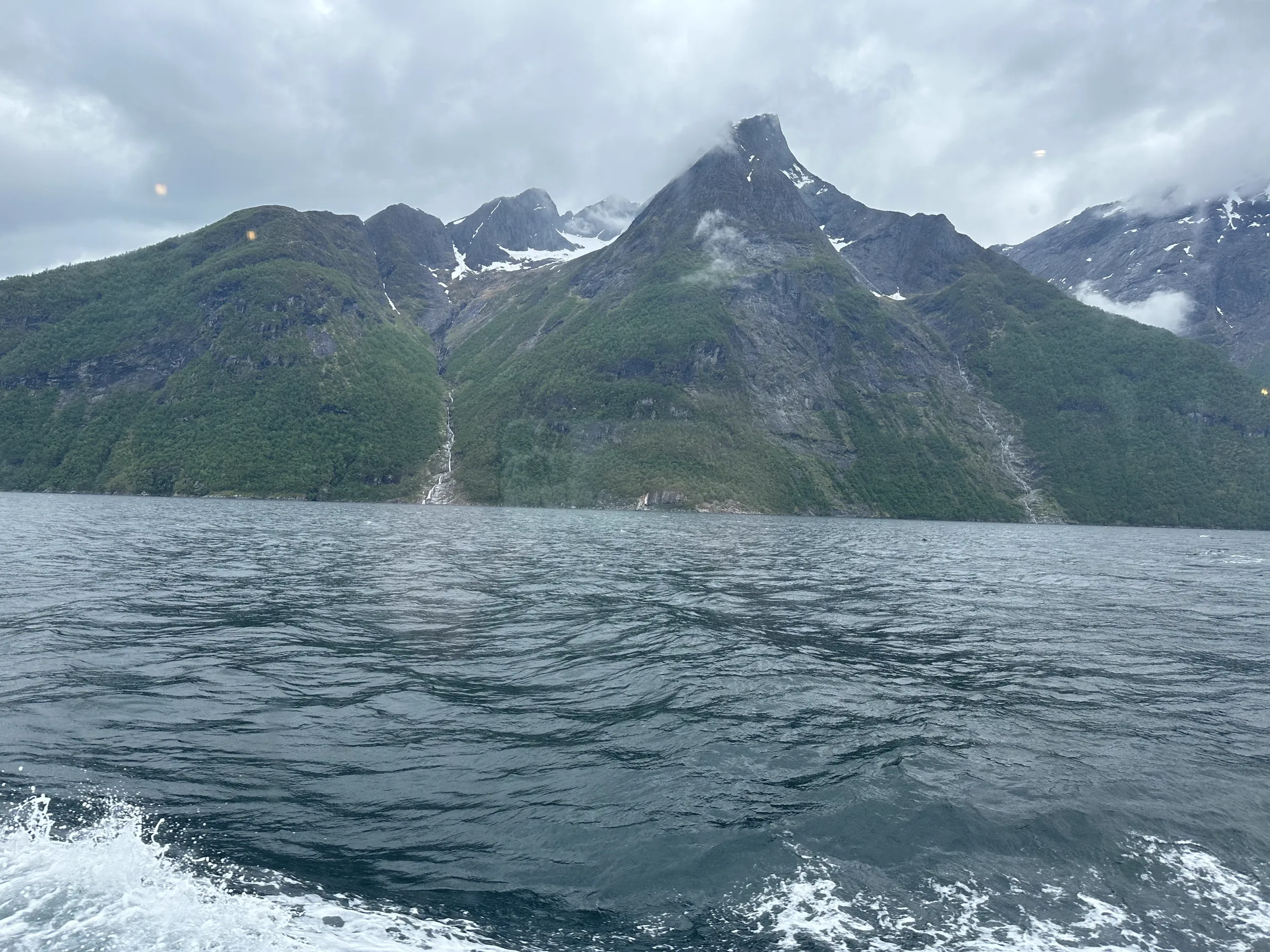 Wide fjord vista with snowy mountains receding into the distance on a spring day