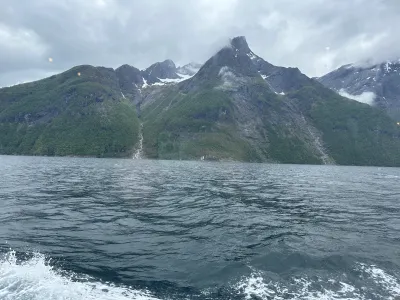 Wide fjord vista with snowy mountains receding into the distance on a spring day