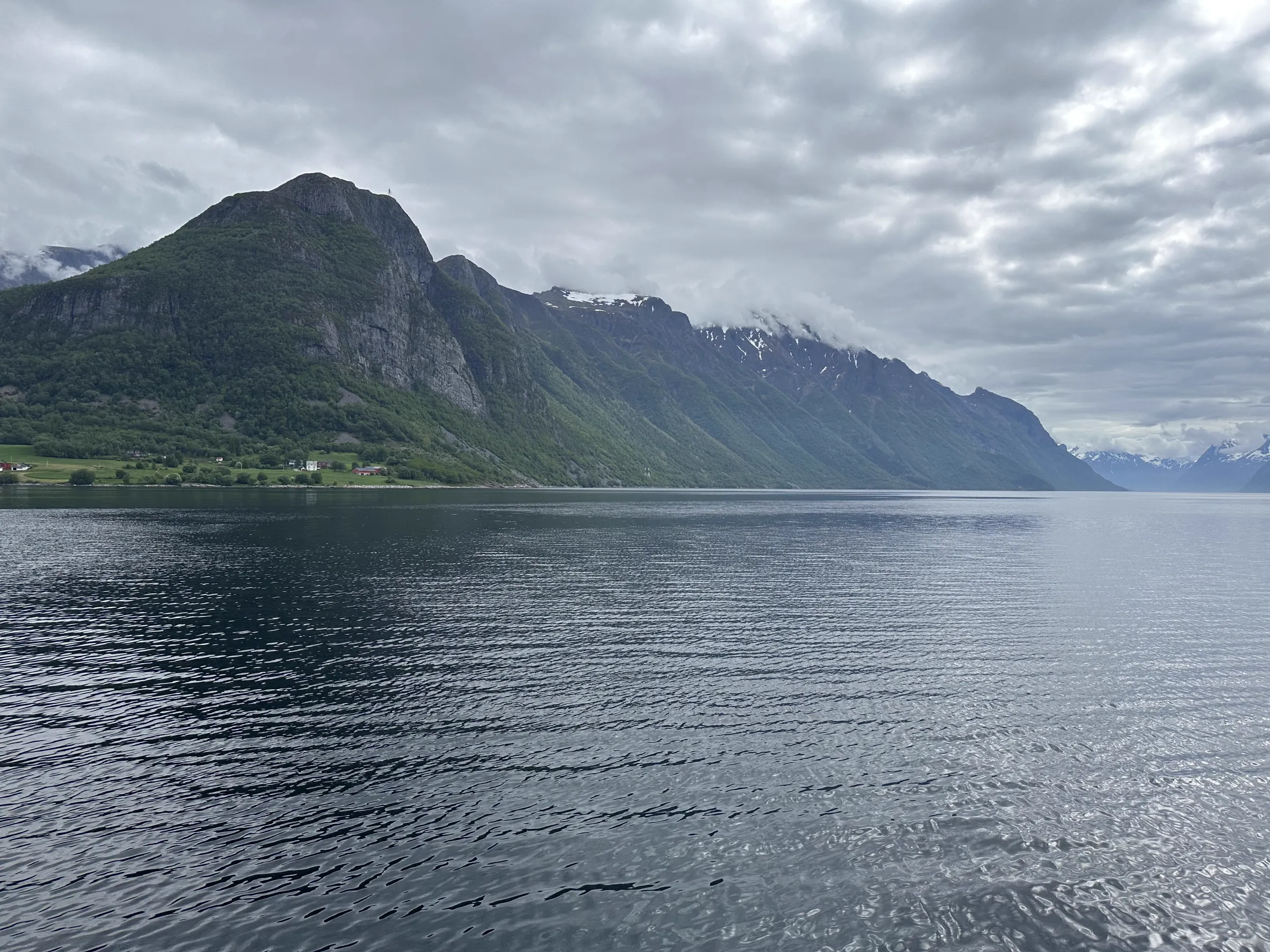 Entrance to the fjord with a massive mountain ridge stretching into the clouds