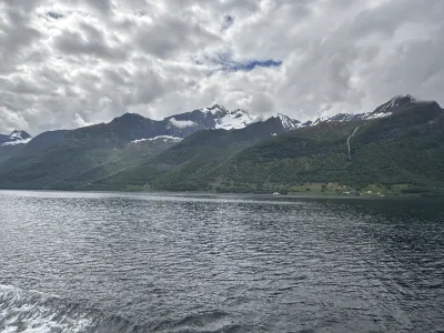 Fjord scenery during the cruise with snow topped mountains and houses littered throughout the scene