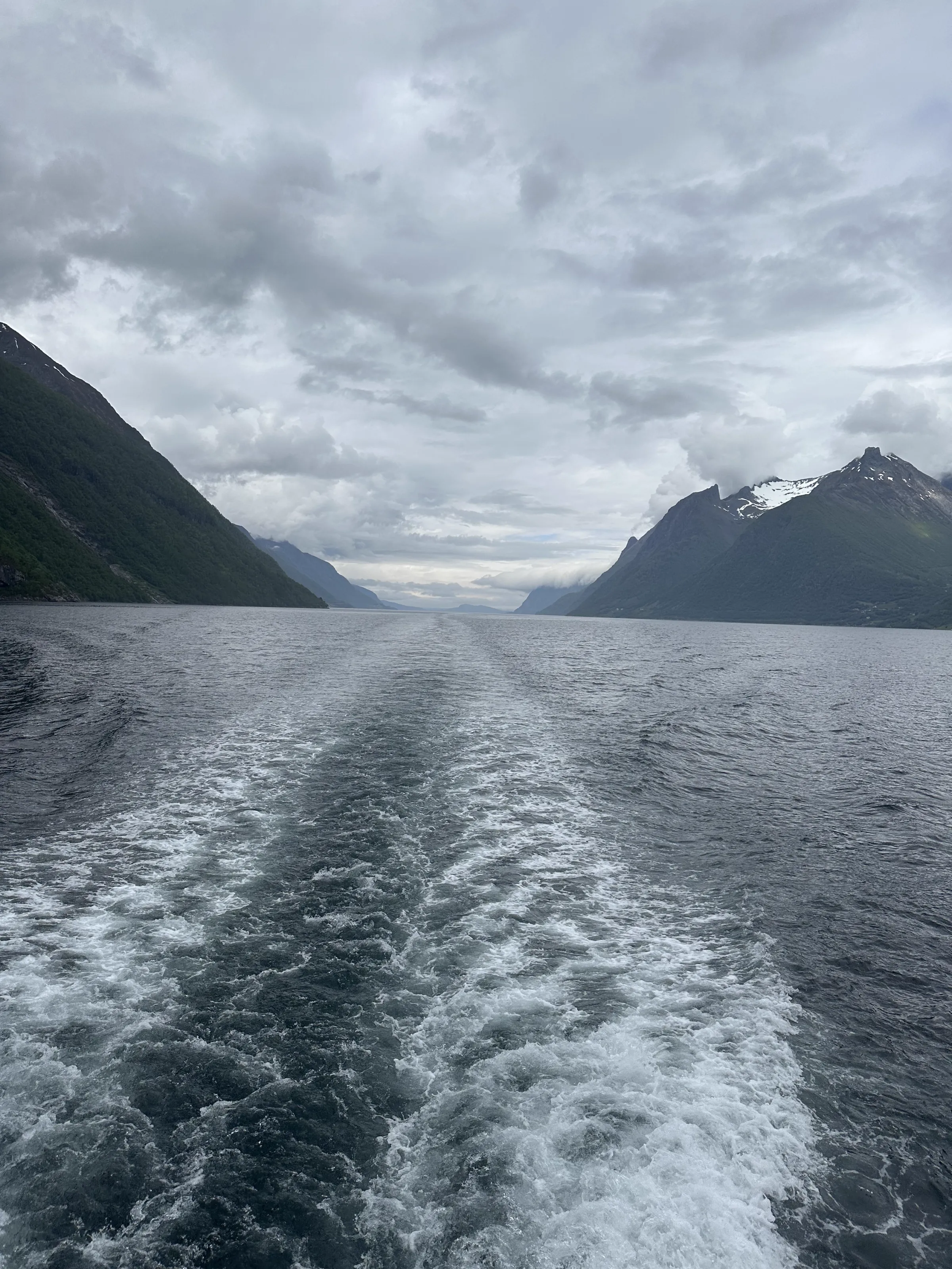 A wide fjord passage with towering cliffs rising steeply on both sides
