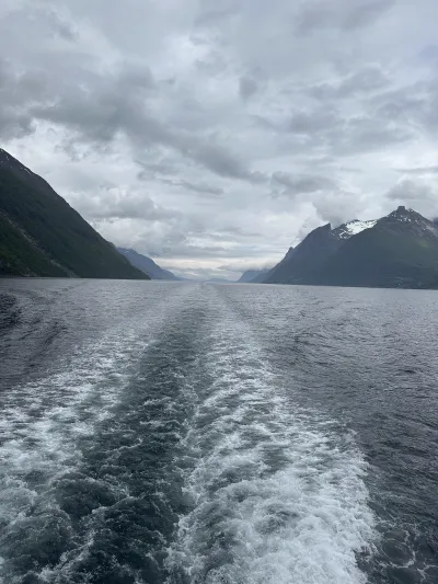 A wide fjord passage with towering cliffs rising steeply on both sides
