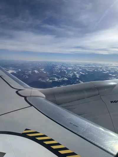 Snow-covered Norwegian mountain ranges viewed from the plane window on the flight from Ålesund to Oslo