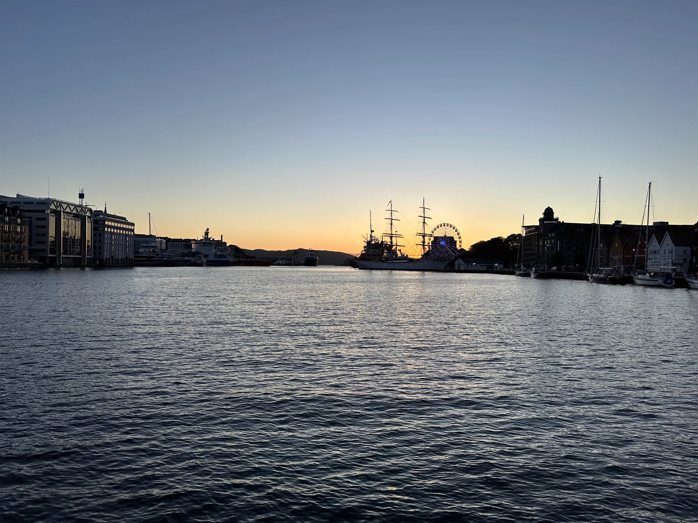 Warm sunset hues washing over Bergen harbour and the surrounding hills